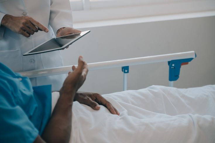 a doctor talking to a patient in a bed