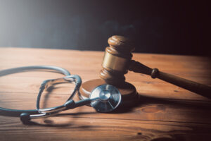 A gavel and stethoscope sit on a desk. 