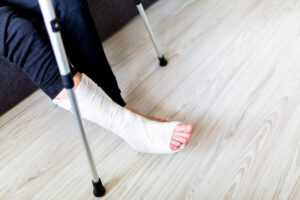 A man with his leg in a cast supported with crutches
