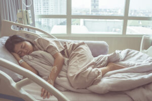 A woman in a hospital bed who has finally received a diagnosis of endometriosis after further tests and is considering pursuing substantial compensation. 