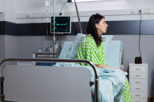 Woman sat on hospital bed.