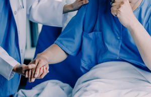 Patient receiving care from a professional in a hospital setting.