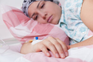 A female patient lying on her side in a hospital bed.