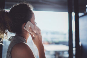 A woman talks on the phone about blood clot compensation.